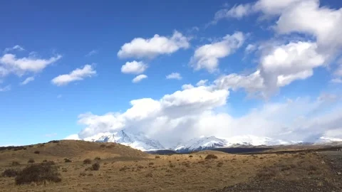 Time lapse of moving white clouds above yellow pampa and hills in Patagonia in Stock-Footage 264808531