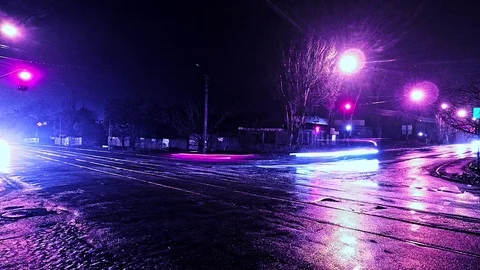 Time lapse night city intersection with traffic and lights reflected on the wet Stock Footage 99676817