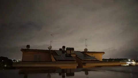 Time lapse by night of clouds above houses with solar panels, after a storm. Stock Footage 125683018