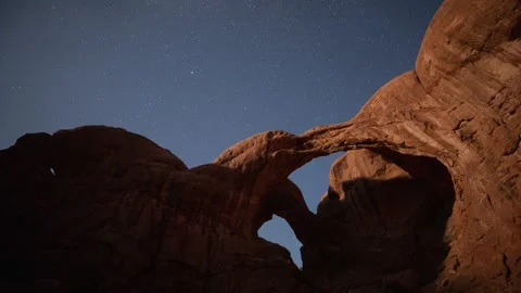 Time lapse of the night sky behind Double Arch in Arches National Park Stock Footage 242128343