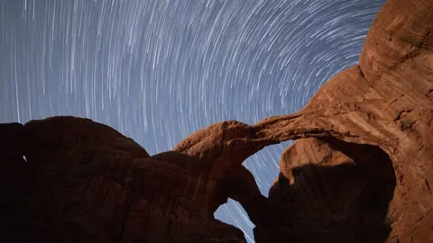 Time lapse of the night sky behind Double Arch in Arches National Park Stock Footage 252102006