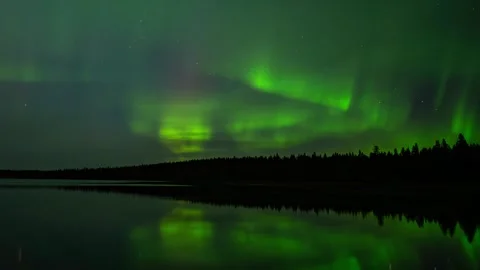 Time lapse of night sky filled with green and yellow Aurora reflecting in a lake Stock Footage 296407076