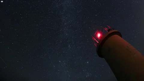 Time lapse of night sky over red lighthouse. Stock Footage