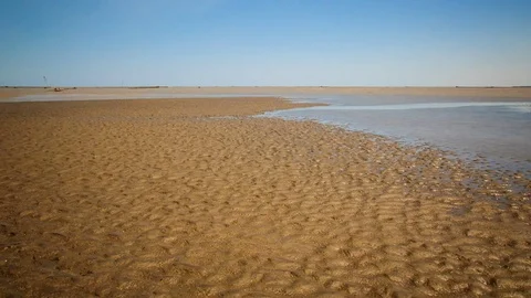 Time lapse of ocean tidal water flooding a sand bank 動画素材 70164249