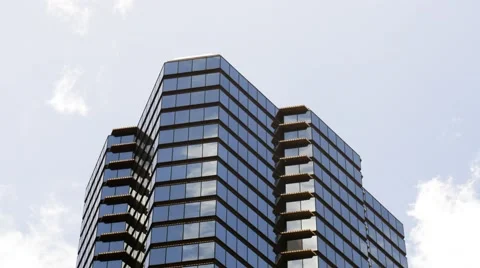 Time-lapse of an office building with reflection of fast moving clouds Video stock 49277655