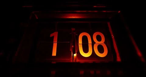 Time lapse of an old orange flip clock counting hours in a dark room Stock Footage 336049341