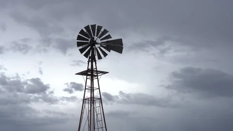 Time lapse of an old windmill silhouetted by rain clouds in the American west Stock Footage 170675311