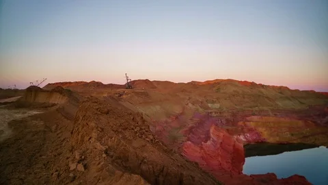 Time lapse of operating mine at suset. Excavators load ore into dump-trucks Stock Footage 75406939