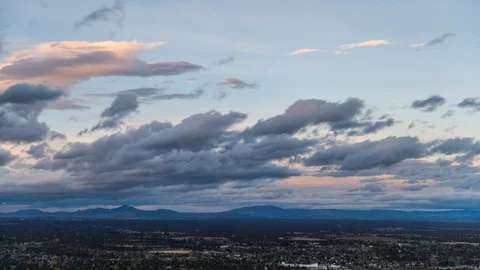 Time-lapse of orange clouds rolling over the town at dusk Stock Footage 87476548