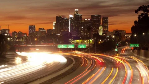 Time lapse of orange sunset clouds, freeway traffic and the Los Angeles skyline Stock Footage 83270970