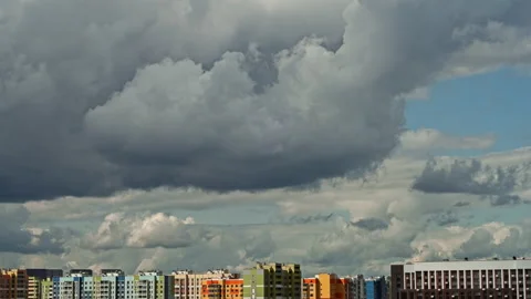 Time lapse over city with fast moving clouds over buildings in the blue sky. Stock Footage 159599994
