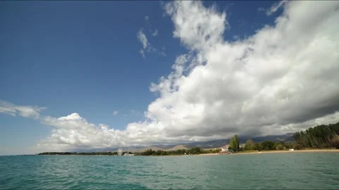 Time lapse over the mountain coastline, white clouds float quickly in the blue Stock Footage 147281430