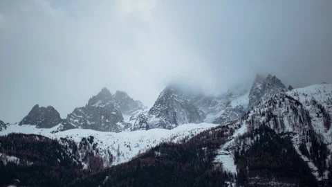 Time-lapse of overcast clouds float over the snowy mountain in winter Stock Footage 116789451