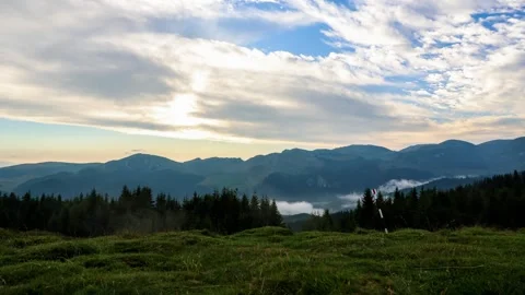Time lapse with pan motion of clouds and misty fog in mountains at sunset Stock Footage 247279643