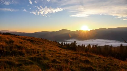 Time lapse with pan motion of clouds and misty fog in the mountains at sunset Stock Footage 247280420