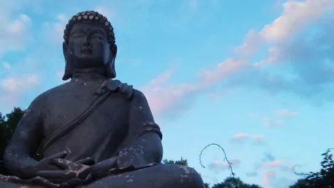 Time lapse pan of a statue of the Buddha with beautiful summer evening sky Stock Footage 137672784