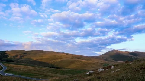 Time lapse with panning motion of clouds moving above hills and mountains Stock Footage 247824336