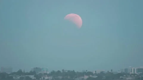Time-lapse of a partial lunar eclipse in the light blue night sky over the Stock Footage 197470002