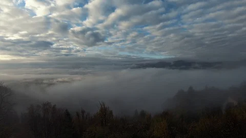 Time lapse partially covered clouds on sky and low fog in valley Video stock 120676900