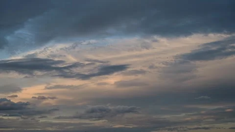 Time lapse of pastel-colored clouds that are moving in two directions. Stock Footage 257957410
