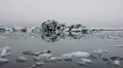 Time lapse of peaces of floating ice and bigger iceberg at Glacier lagoon Stock Footage 33778480