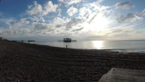 Time lapse of pebble beach, sea and West Pier ruins under bright sun and cloudy Stock Footage 342291501