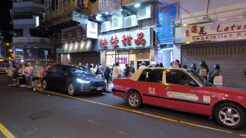 Time lapse of people bustle around popular dessert restaurant entrance at night Stock Footage 309440168