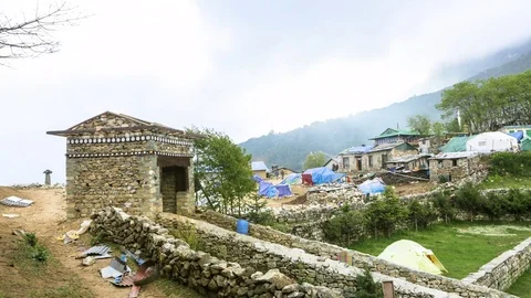 Time-lapse of people moving around the stone houses in rural area Stock Footage 77452358