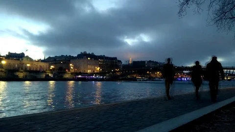Time lapse of people walking alongside Seine river in Paris at dusk sunset Stock Footage 71533364