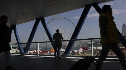 Time Lapse of people walking through a pedestrian bridge near a Ferris wheel Stock Footage 45380085