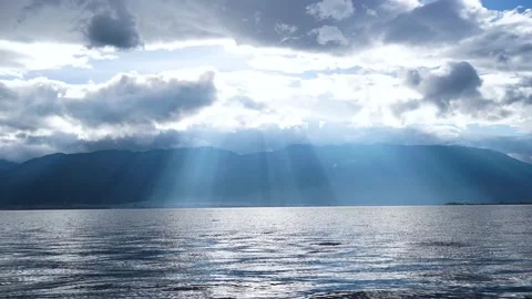 Time lapse photography of lake surface crepuscular ray layered flowing cloud 스톡 동영상 337923962