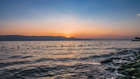 Time lapse photography of lake surface wave dusk gradient glow flowing cloud Stock Footage 337923970