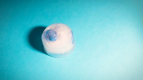 Time lapse of a piece of melting ice and inside there is a dead blue fish Stock Footage 100022935