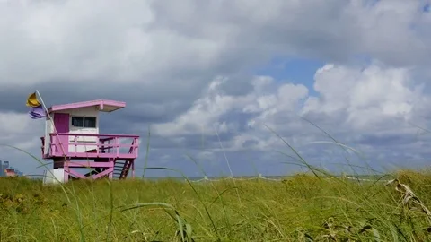 Time lapse of pink and white lifeguard house with grass in foreground Stock Footage 72801155