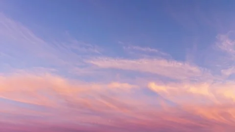 Time lapse of pink clouds and blue sky at sunset. Stock Footage