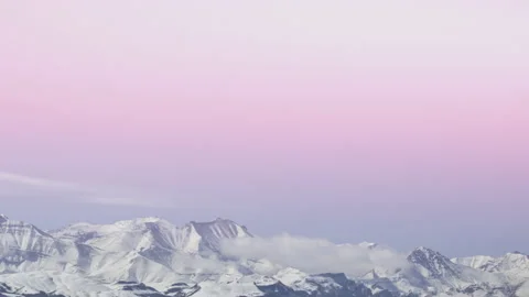 Time lapse. A pink pastel colored dawn over the mountain range with boiling clou Stock-Footage 166048876