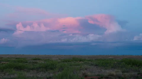 Time lapse of a pink storm cloud above flat arid terrain in New Mexico at sunset Stock Footage 158335729