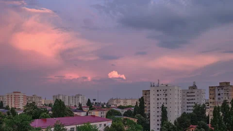 Time lapse of pink sunset clouds over communist era buildings in Eastern Europe. Video stock 136177755