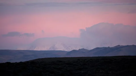 Time lapse of pink sunset clouds and snowy White Mountains in California Stock Footage 136853514