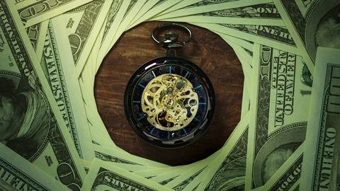 Time lapse pocket watch on the floor among dollar banknote stacking in darkness. Stock Footage 115958730