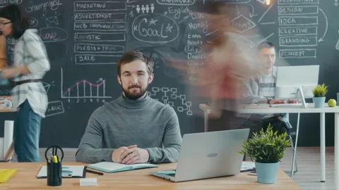 Time lapse portrait of bearded guy sitting at desk and looking at camera in Stock Footage 133042505