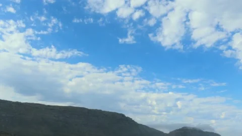 Time lapse as pre-frontal clouds roll in over a mountain on a sunny day Stock Footage 154410700