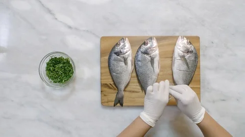 Time lapse of preparing sea bream: slice, sprinke salt, and stuff coriander Video stock 122235649