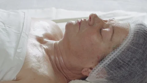 Time lapse, the process of drying an alginate mask on the face of an elderly Stock Footage 318606178