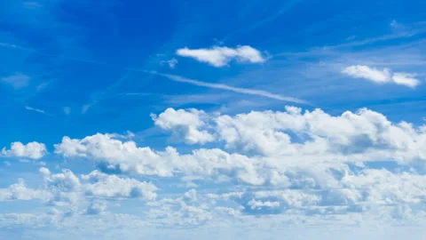 Time lapse of puffy clouds rolling through a bright blue sky Stock Footage 306074449