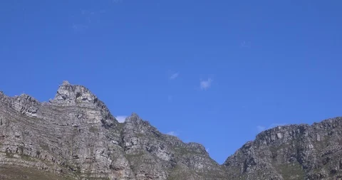 Time lapse of puffy clouds sailing over jagged mountain ridge in Capetown Stock Footage 104060585