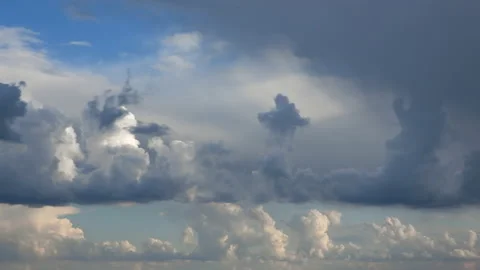 Time-lapse | puffy storm clouds dance through the blight blue sky Stock Footage 197433539