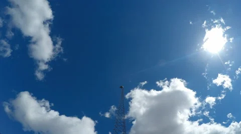 Time Lapse of puffy white clouds and blue skies with Television Broadcast Tower Stock Footage 61439649