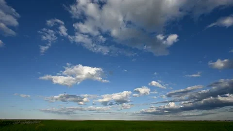Time lapse of puffy white clouds in a blue sky are moving away from the viewer Stock Footage 172217957