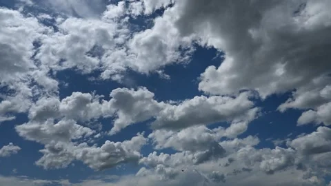 Time lapse of puffy white cumulus clouds churning in a blue sky Stock Footage 337847331